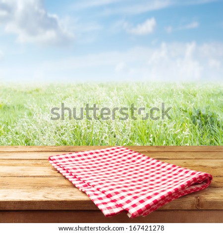 Wooden table with tablecloth over meadow