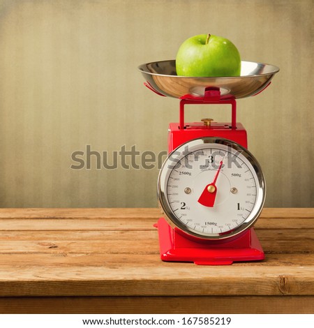 Apple On Vintage Scale On Wooden Table