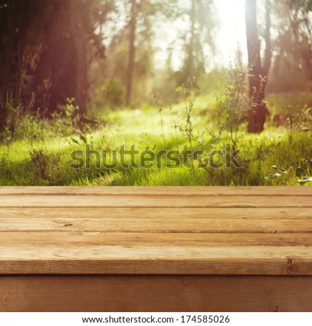Empty wooden deck table over forest background. Ready for product montage display