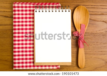Blank note book with wooden spoon on tabletop