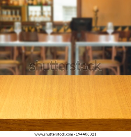 Empty wooden modern table inside restaurant, bar or coffee shop