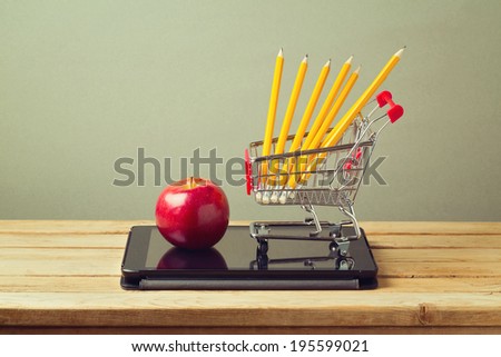 Back to school concept. Apple and pencils with tablet device on wooden table