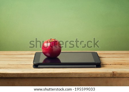 Back to school concept. Apple and tablet device on wooden table