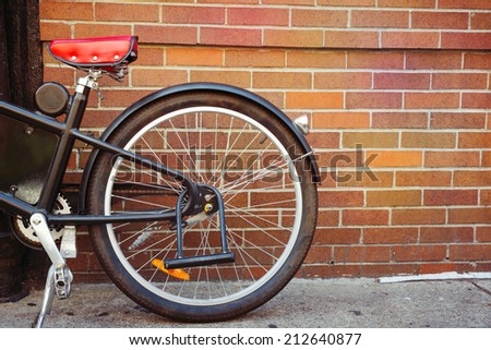 Vintage bicycle detail over brick wall background