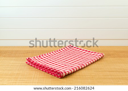 Wooden counter with red checked tablecloth for product montage background