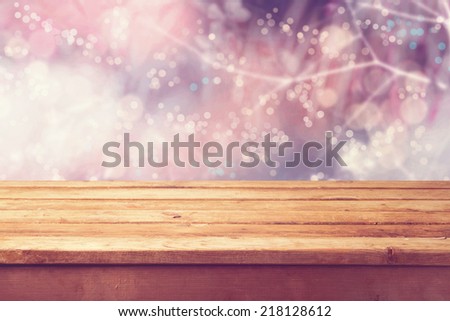 Beautiful winter bokeh background and wooden table. Ready for product montage