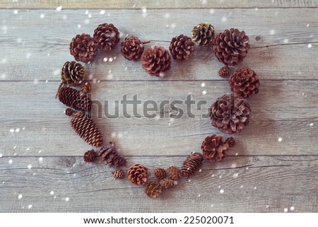 Heart shape frame from pine corn on wooden background