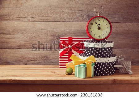 Gift boxes and watch on wooden table. New Year celebration concept