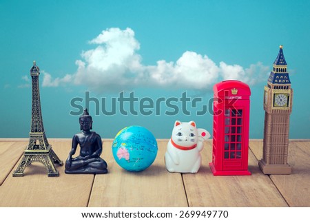 Travel around the world concept. Souvenirs from around the world on wooden table over blue sky background