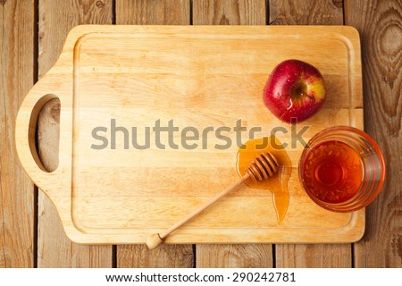 Jewish Rosh Hashana holiday background with apples and honey on wooden board. View from above
