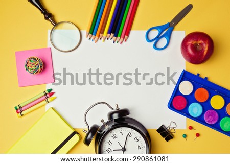 Back to school background with blank white paper and school supplies. View from above