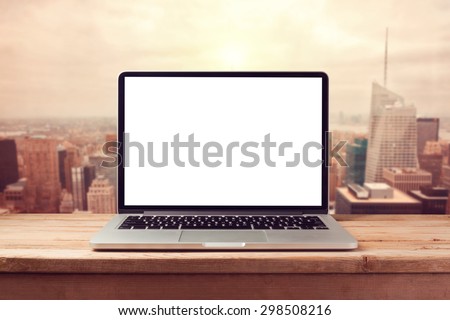 Laptop computer mock up over city skyline. Retro filter effect