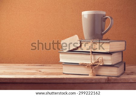 Old vintage books with cup and price tag on wooden table. Back to school concept
