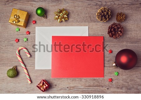 Greeting card mock up template with Christmas decorations on wooden background. View from above