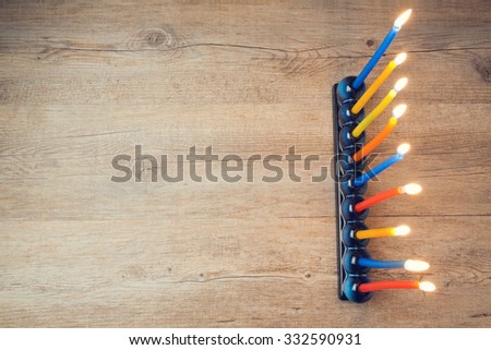 Jewish holiday Hanukkah creative background with menorah on wooden table. View from above.  Retro filter effect.