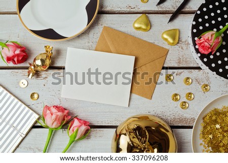 Greeting card mock up template with rose flowers and chocolates on wooden background. View from above