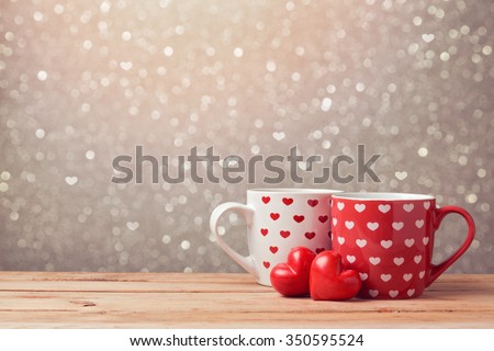 Valentine\'s day holiday celebration with hearts and cups over bokeh background