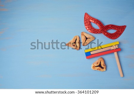 Jewish holiday purim background with carnival mask and  hamantaschen cookies. View from above