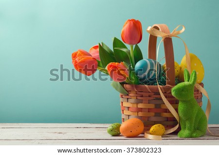 Easter holiday basket with eggs, flowers and easter bunny