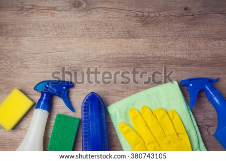 Cleaning concept with supplies on wooden background. View from above