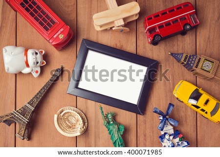 Travel and tourism concept with frame mock up template and souvenirs from around the world. View from above