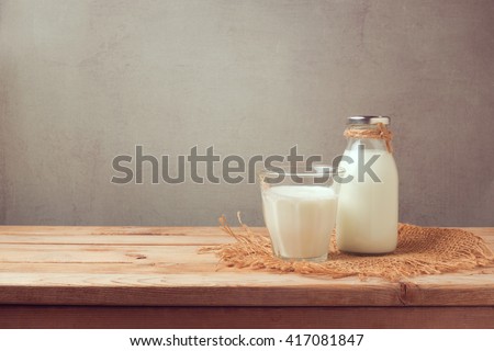 Milk bottle and milk glass on wooden table. Healthy eating concept