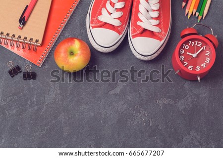 Back to school background with school supplies over blackboard. Top view. Flat lay