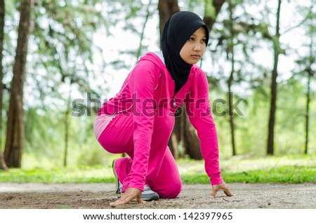 Muslim woman in starting position and ready to race in sports