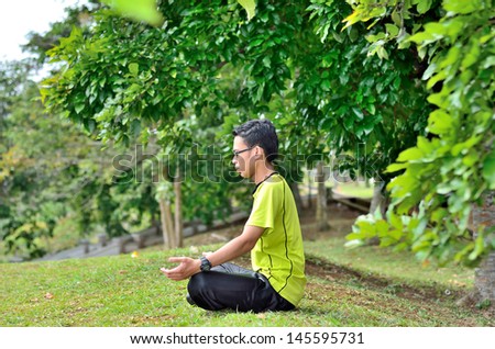 Young man meditating outdoors