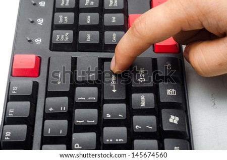 Finger pushing the button ENTER on the keyboard