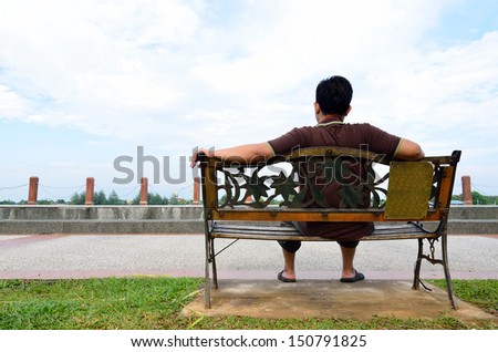 Young man sit on the bench at the park