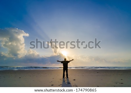 Silhouette of Man Raising His Hands or Open arms when sunrise