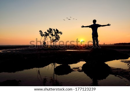 Silhouette of Man Raising His Hands or Open arms when sunset