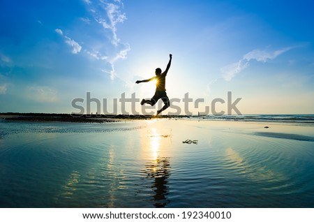 Silhouette of a man jumping over sun rising up