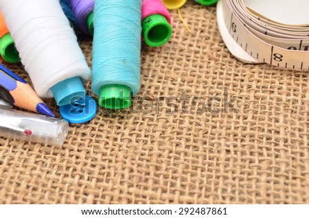 Sewing kit. Scissors, bobbins with thread and needles on the old fabric