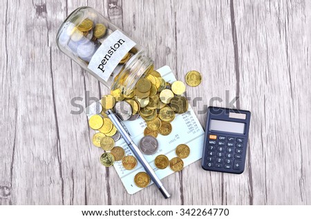 Coins, calculator and pen on bank account book with label pension