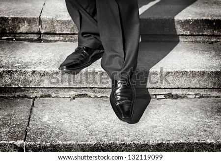 Businessman legs taking step on a lower level on a stairs - bad investment decision concept