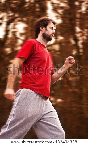 Forty years old man during a running workout in autumn forest