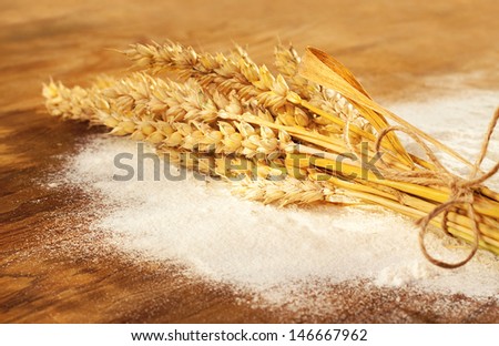 Wheat bunch and flour on vintage wood board - rural still life