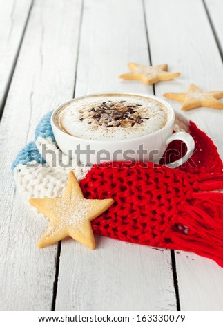 Winter Cappuccino Coffee In A Cup With Star Shaped Christmas Cookies And Warm Scarf On White Planked Wood Background - Rural Still Life