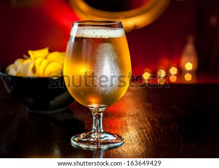 Beer Glass And Potato Chips In Elegant Restaurant, Pub Or Cocktail Bar Interior