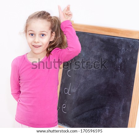 Happy smiling five years old caucasian blond child girl in front of blackboard on white background - education
