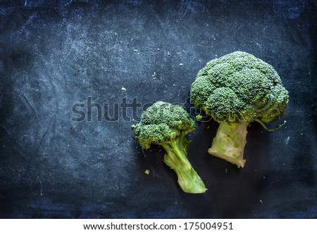 Raw Broccoli On Black Chalkboard. Background With Free Text Space.