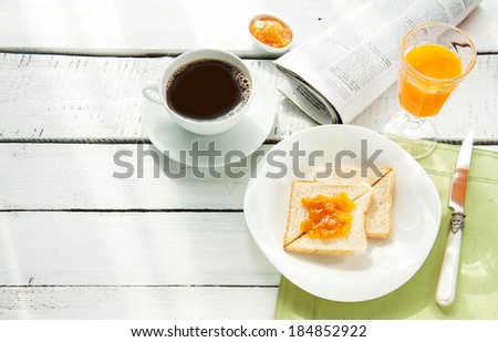 Continental breakfast - coffee, orange juice and toast on white wood table. Background with free text space.