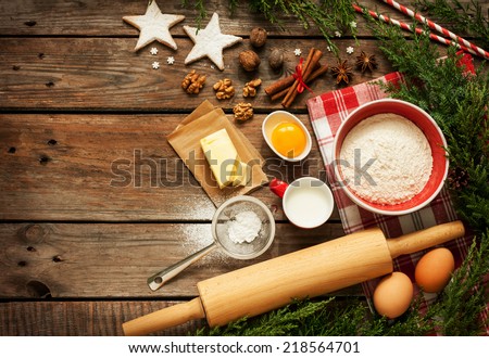 Christmas - baking cake background. Dough ingredients and decorations on vintage planked wood table from above. Rural kitchen layout with free text space.