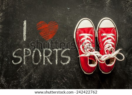 I love sports - poster design. Red sneakers on black chalkboard from above.