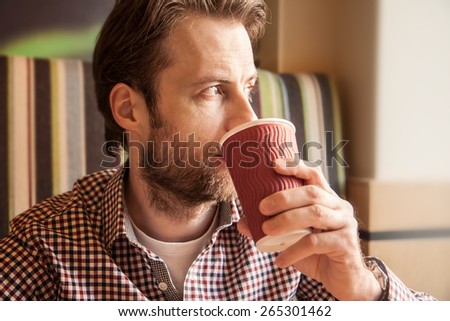 Close up portrait of forty years old caucasian man in casual outfit drinking coffee in a cafe - city lifestyle.