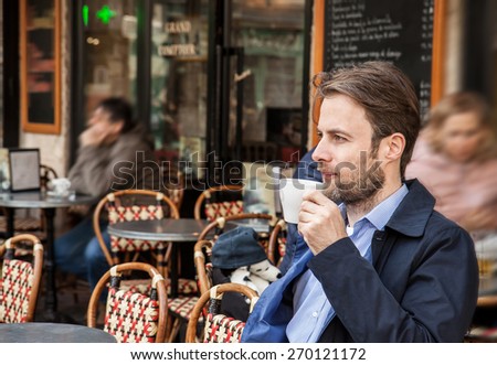Portrait of forty years old caucasian man in casual outfit drinking coffee in Paris cafe. City lifestyle - relax.