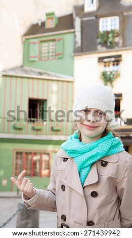Happy smiling six years old caucasian blond child girl in Paris. Old historic buildings as background.