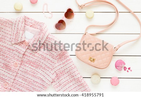 Pastel theme mood board with pink jacket and fashion accessories (bag, sunglasses) for girls. White rustic wooden background. Flat lay composition (from above, top view).